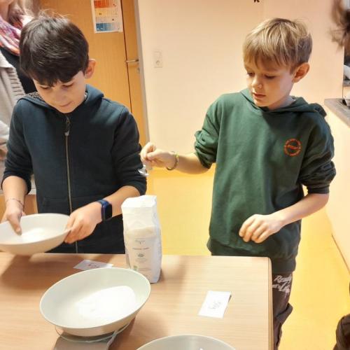 Kinder wiegen Mehl fürs Keks backen