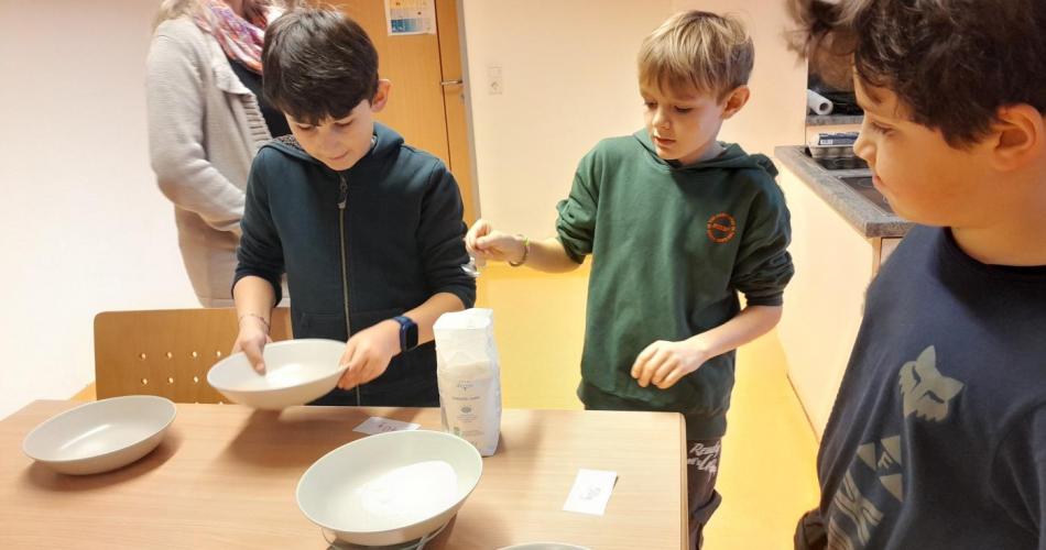 Kinder wiegen Mehl fürs Keks backen